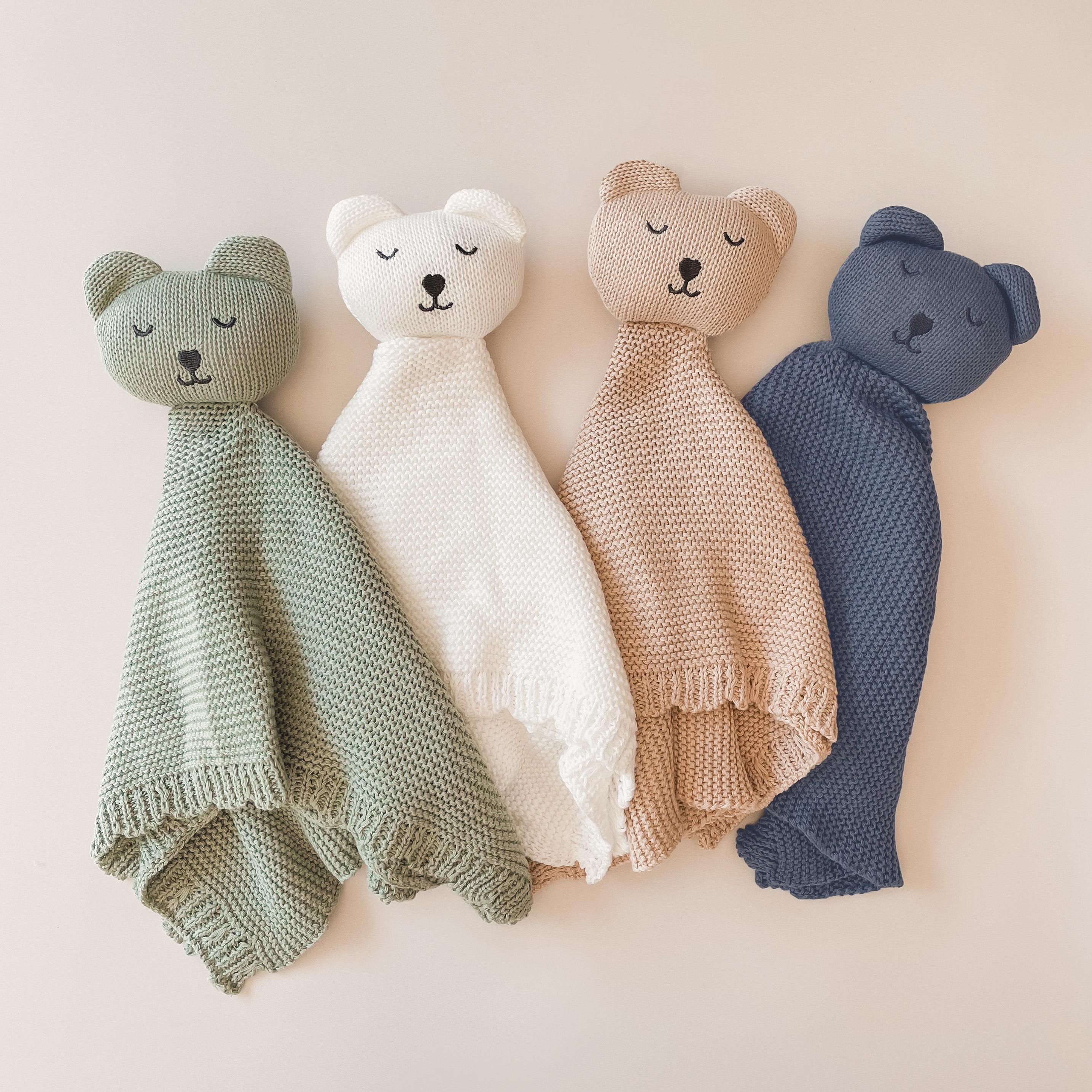Cute cotton knit baby comforter in the shape of a bear. Available in four colour options of Milk, Oatmeal, Sage or Blue, this comforter makes an ideal gift for a baby shower or to celebrate the arrival of a new baby.